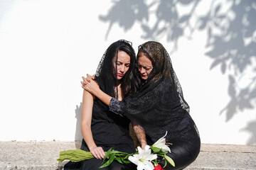 Mother and daughter mourning at the cemetery