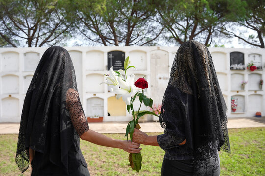 Mother and daughter mourning in cemetery