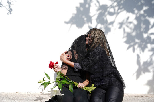 Mother and daughter mourning in the cemetery