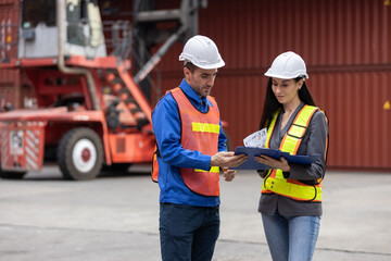 Logistics workers in safety gear coordinating operations at container yard, with male supervisor...