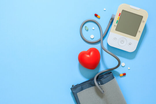 Blood pressure monitor and heart on blue background