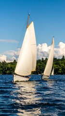 Obraz premium Two sailboats on a lake under a vibrant blue sky