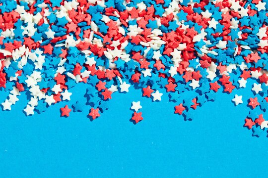 Colorful star shaped sugar sprinkles on blue background