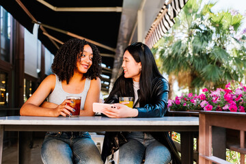 Gen z friends enjoying drinks at an outdoor bar