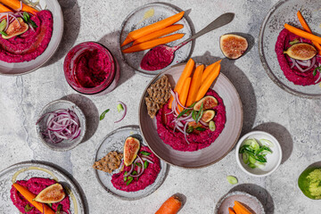 Top view of colorful beet hummus with fresh vegetables
