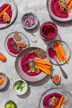Top view of vibrant beet hummus with fresh garnishes