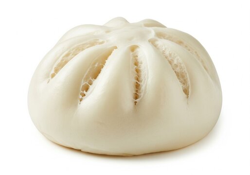 A soft, white, steamed bun is resting on a clean white surface. Its delicate folds are visible, indicating the filling inside this pastry. Isolated white background.
