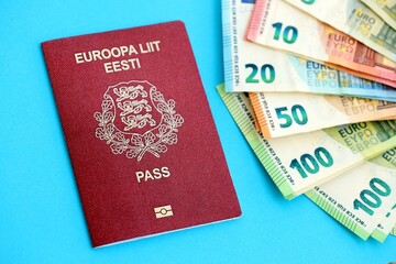Estonia passport lies with euro money banknotes on blue background. Salary and pension in Europe