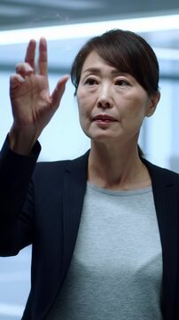 Diverse professional in business casual manipulates vibrant holographic data with fluid gestures in a minimalist futuristic workspace, bokeh background. Dolly video highlights rim lighting. high-tech