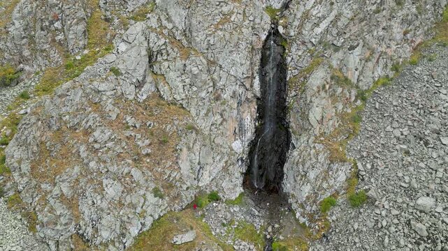 Aerial view of Ak-Sai Waterfall cascading down rocky cliffs in Ala Archa National Park, Kyrgyzstan.
