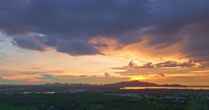 The shoreline falls quiet as twilight deepens. Golden beams linger across the mountain ridges, palm forests, and ocean waves, painting the entire scene in serene harmony of dusk and nature.