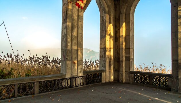 Stone gazebo overlooking a misty landscape