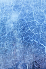Unusual texture of thin mesh ice on coastal rocks of Baikal Lake on cold winter day. Blue ice natural abstract background with cracks. Christmas blank  for design, copy space, close-up