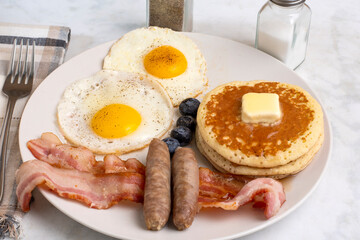 fried eggs wih pancakes and  bacon
