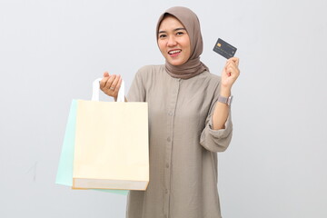 Young stylish asian muslim woman holding shopping bags and credit card. Isolated on white background