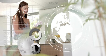 Woman picking smartphone in kitchen, swiping to browse business data and animating globe and charts - Powered by Adobe