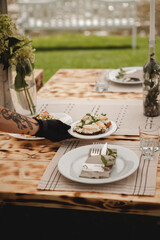 The waiter sets the wedding table and serves sandwiches.