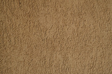 Closeup of plastered exterior wall of beige color. Textured background.