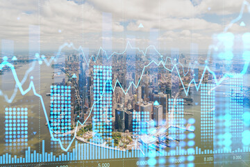 Aerial view of Manhattan with a futuristic digital financial chart hologram over the cityscape. Concept of finance and technology. Double exposure
