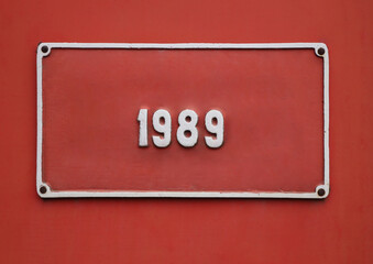 20th century 1989 th year one 1 red rectangular square frame is hanging on red painted wall with urban grunge historical background 1989 year produced