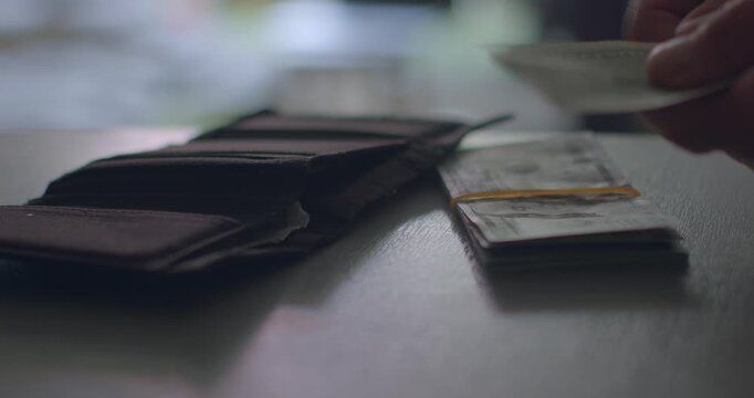 A detailed closeup image showing wallets and neatly bundled cash placed on a tabletop, which effectively illustrates a setup for making financial transactions between parties