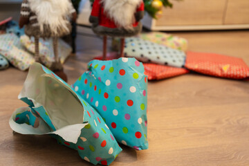 Fototapeta premium Opened christmas gift lies on floor near christmas tree