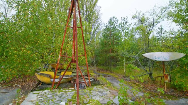 Footage of the eerie and overgrown amusement park in Pripyat, Ukraine, located within the Chernobyl Exclusion Zone. This iconic Ferris wheel and bumper car area stand as a poignant reminder of the 198