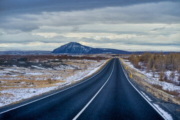 Road way for travel in Iceland with the landscape mountain peak view in heavy storm cloud.