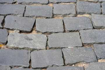  Detailed view of a cobblestone street surface featuring a slightly uneven pattern.The textures and arrangement highlight the historical charm of urban paving.