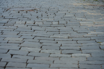  Detailed view of a cobblestone street surface featuring a slightly uneven pattern and a visible...