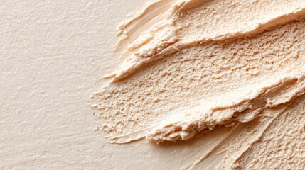Smooth beige cream texture with brush strokes, skincare concept.