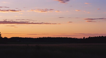 A serene evening landscape featuring a colorful sunset sky with warm orange and pink hues over a dark forest silhouette