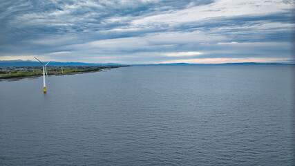雨が降りそうな9月の富山県入善町沿岸からみる洋上風力発電風車をはじめとする様々なもの