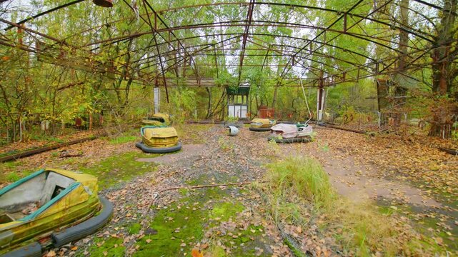 An eerie scene of abandoned bumper cars in the overgrown amusement park of Pripyat, Ukraine, a ghost town within the Chernobyl Exclusion Zone, symbolizing the aftermath of the 1986 nuclear disaster.