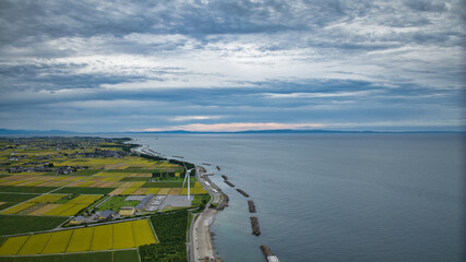 雨が降りそうな9月の富山県入善町沿岸からみる洋上風力発電風車をはじめとする様々なもの