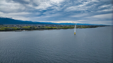 雨が降りそうな9月の富山県入善町沿岸からみる洋上風力発電風車をはじめとする様々なもの