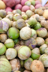 The image shows a large pile of tomatillos—small, round fruits encased in papery husks.