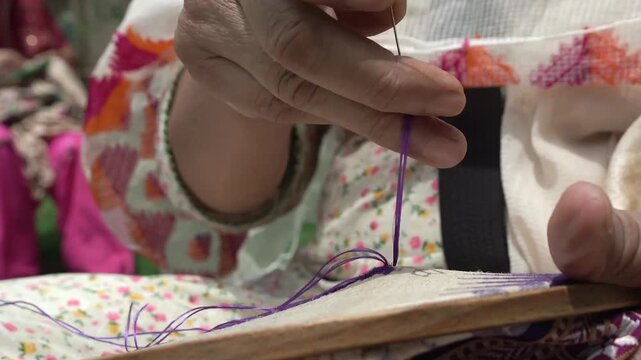 Closeup shot of Women doing hand embroidery. phulkari embroidery tradition of Punjab.