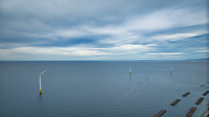 雨が降りそうな9月の富山県入善町沿岸からみる洋上風力発電風車をはじめとする様々なもの