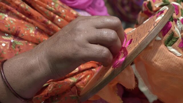 Closeup shot of Women doing hand embroidery. phulkari embroidery tradition of Punjab.