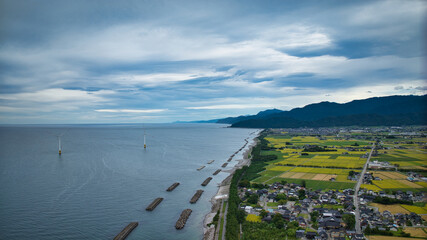 雨が降りそうな9月の富山県入善町沿岸からみる洋上風力発電風車をはじめとする様々なもの