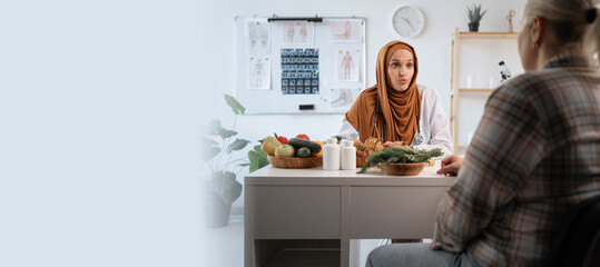 Weight loss consultation. Muslim young nutritionist woman consultation to patient and making...