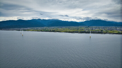 雨が降りそうな9月の富山県入善町沿岸からみる洋上風力発電風車をはじめとする様々なもの