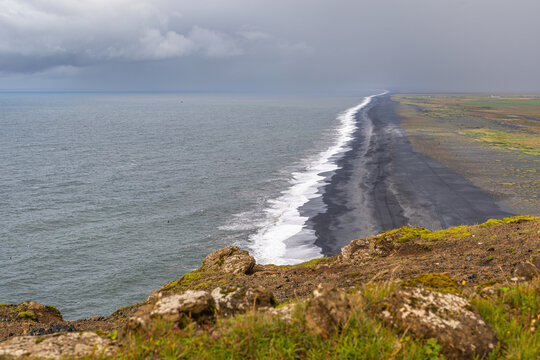 Plage de Solheimafjara, au sable noir volcanique, depuis le phare de Dyrh&oacute;laey, dans le sud de l'Islande