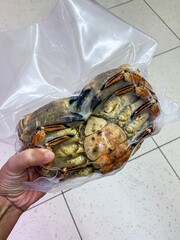 Frozen crab in vacuum-seal bag, culinary curiosity for seafood sustainability, celebrated during National Crab Meat Day, coastal gastronomy allure