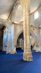 Ancient stone arches bathed in mystical light, echoing medieval history and Celtic Samhain, beaconing tranquility beneath cathedral blue