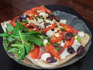 Homemade gourmet pizza on a rustic wooden board, top view
