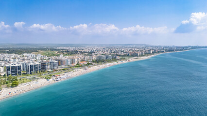 Obraz premium Aerial drone view of Antalya cityscape and Konyaalti beach, people sunbathing on sand, swimming in sea and relaxing, Antalya holiday vacation resort in Turkey