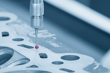 The multi-axis CMM machine measuring the aluminum cylinder head parts.