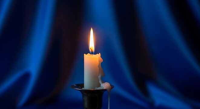 Single lit candle casting a warm glow against a blurred blue background.